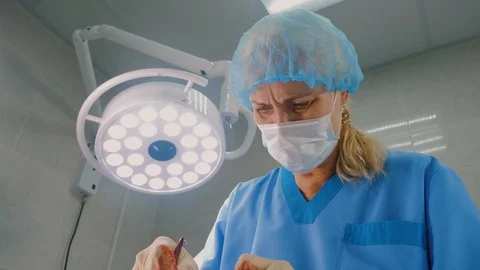 Female experienced surgeon is performing operation in modern clinic Stock Footage 128713413