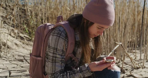 Female Explorer Looking At Compass Surrounded by Reeds Stock Footage 238553786