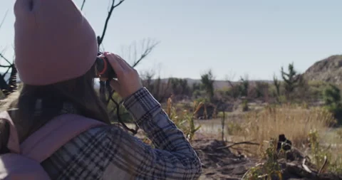 Female Explorer Looking Through Binoculars and into Distance Stock Footage 238553442