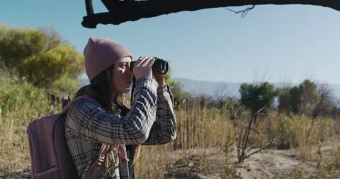 Female Explorer Looking Through Binoculars in Desert Oasis Stock Footage 238553473