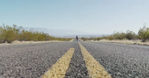 Female Explorer Walks Down Middle of Highway Far Stock Footage 238554335