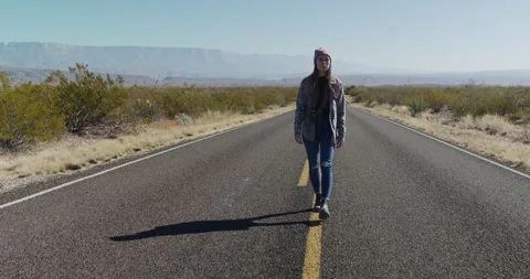 Female Explorer Walks Down Middle of Highway Stock Footage 238554481