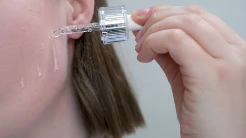 Female face and dropper with moisturizing serum close-up on a gray background. Stock Footage 277385339