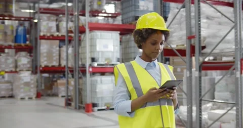 Female factory manager using digital tablet in warehouse while standing against Stock Footage 151401906
