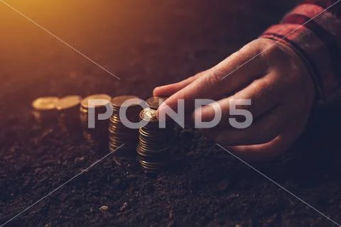 Female farmer stacking coins, success in agriculture Stock Photos