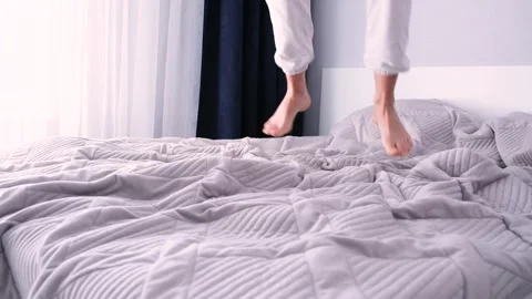 female feet jumping on bed at home | Stock Video | Pond5