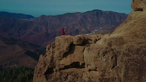 A female figure on the edge of a cliff Stock Footage 228619094
