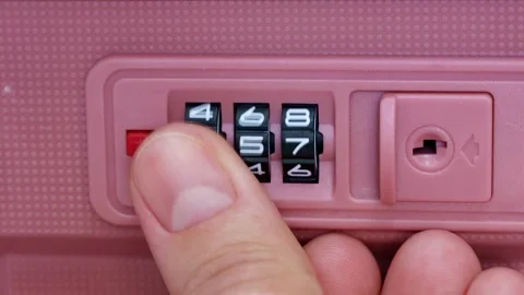 Female finger dials the code on the lock of a pink travel luggage suitcase Stock Footage 264967468