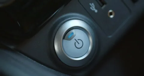 Female finger pressing an engine start stop button on modern electric car Stock Footage 194491642