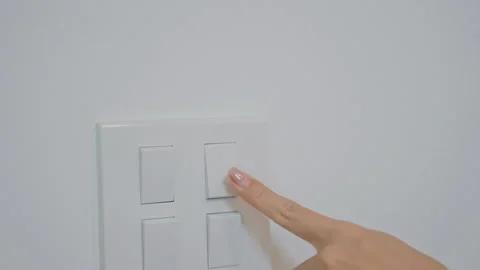 Female finger pushing for turn on light switch on white wall at home room. .. Stock Footage 303804570