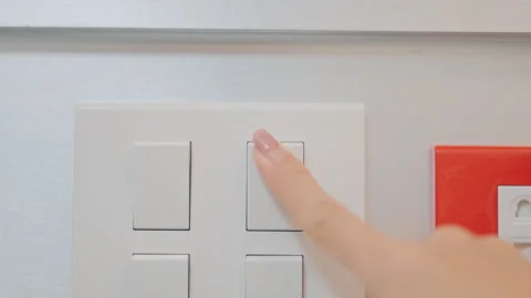 Female finger pushing for turn on light switch on white wall at home room. .. Stock Footage 313969849