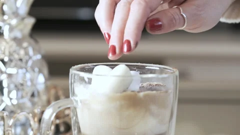 Female fingers poke marshmallows that float in coffee Video stock 144657290