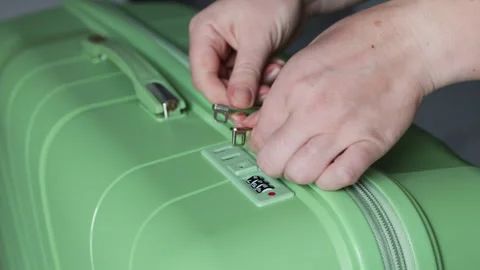 Female fingers pull the tab to close the green luggage. Stock Footage 312638928