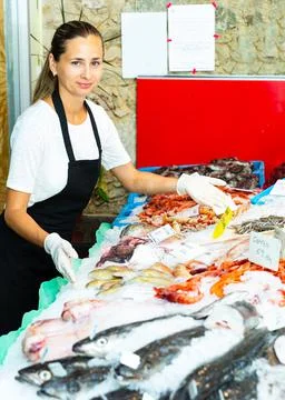Female fishmonger offering seafoods Stock Photos