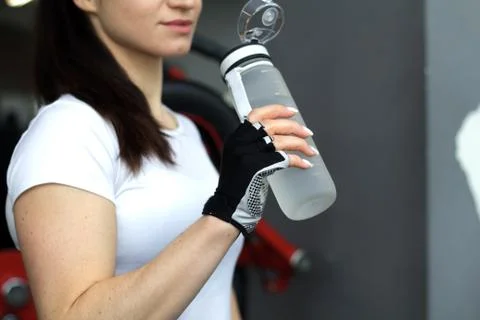 Female fitness model at gym with grey bottle Stock Photos