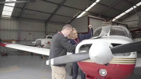Female flight instructor teaching her student how to do the maintenance of th Video stock 146375950
