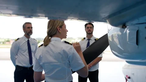Female flight instructor teaching pilots airplane pre flight inspection Stock Footage 336380194