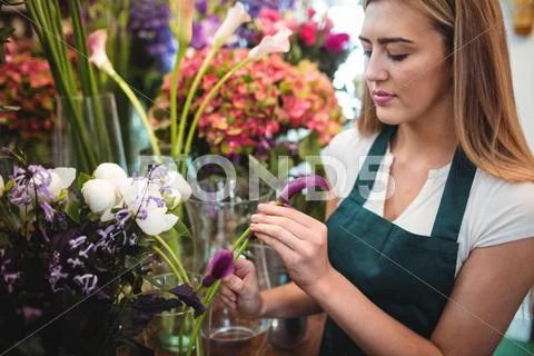 Female Florist Arranging Flowers At Her Flower Shop