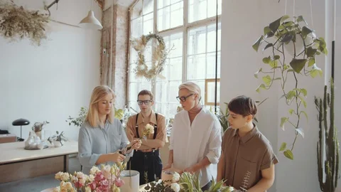 Female Florist Teaching Group of Man and Women How to Cut Flower Stem Stock Footage 128138363