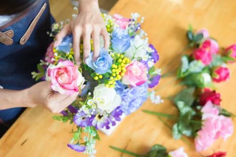 Female Florist at work using Arranging making beautiful Artificial bouquet ve Stock Photos