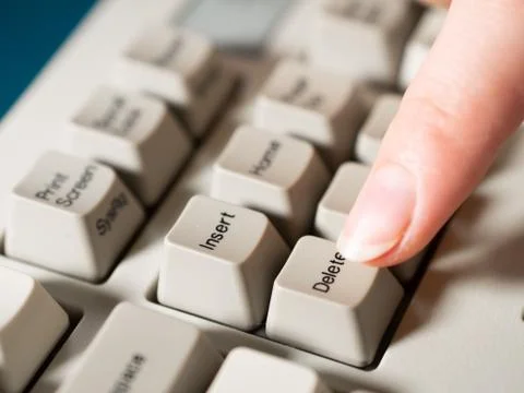 Female forefinger pushes DELETE button. Close-up Stock Photos