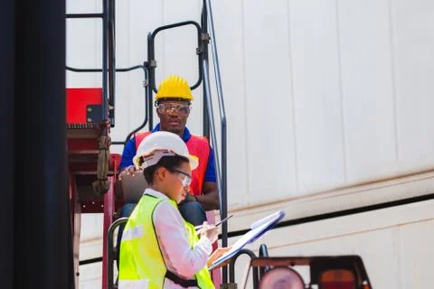 Female foreman using clipboard checklist and Worker man control loading Stock Photos