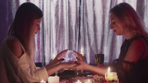 Female fortune teller takes client hand and they together touches magic cristal Stock Footage 143515380