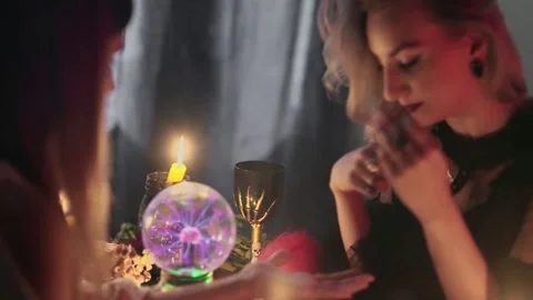 Female fortune teller uses a magic pendulum on client hand and reading palm Stock Footage 143513599