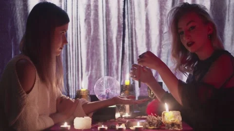 Female fortune teller uses a magic pendulum on client hand and reading palm Stock Footage 143514989