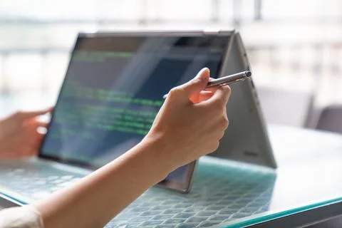 Female freelance developer coding and programming. Coding on two with screens Stock Photos