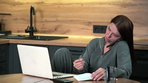 Female freelancer brainstorming while sitting at kitchen table. Stock Footage 301656321