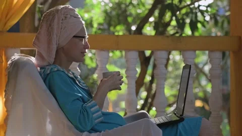 Female freelancer communicates via video link on a terrace in sunlight. Stock Footage 239051103