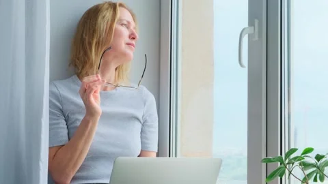 Female freelancer looking out the window making pause in work. Stock Footage 246778262