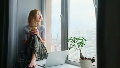 Female freelancer looking out the window while a break in work. Stock Footage 250171878
