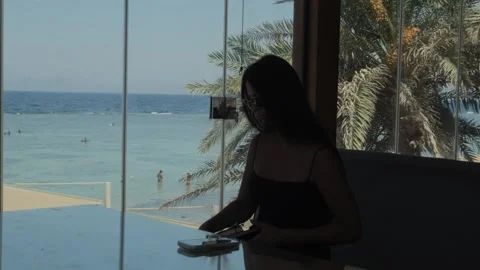 Female freelancer setting up laptop and notebook to start remote work at seaside Stock Footage 346252447