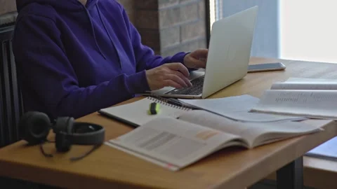 Female freelancer sitting brown table typing keyboard opened laptop, textbooks Video stock 243268699