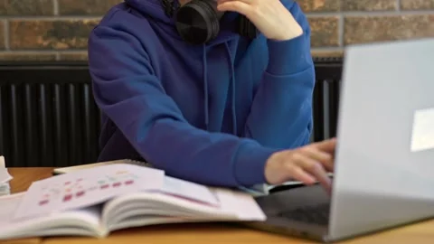 Female freelancer sitting brown table typing keyboard opened laptop, textbooks Video stock 243269083