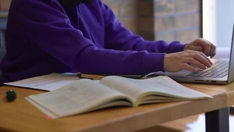 Female freelancer sitting brown table typing keyboard opened laptop, textbooks Stock Footage 243269247