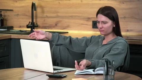 A female freelancer is surprised while working while sitting at the table in the Stock Footage 301659560
