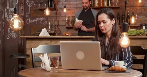Female freelancer at a table in coffee shop waits for her colleague at a lunch Stock-Footage 103376517