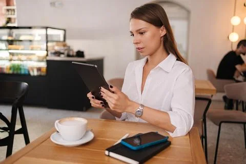 Female freelancer working in cafe using digital tablet. Young business manager Stock-Fotos