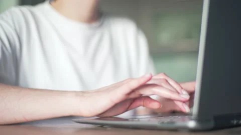 A female freelancer working at home performs the task of typing on a laptop Stock Footage 130209618