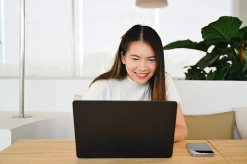 A female freelancer is working using a laptop on a working plane. The photo is Stock Photos