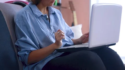 A female freelancer works from home while sitting on the couch. Stock Footage 149272575