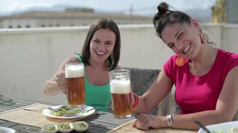 Female friends drinking beer on the terrace Stock Footage