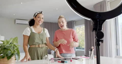 Female friends starting beauty tutorial demonstrating perfume spray under ring Stock Footage 313903828
