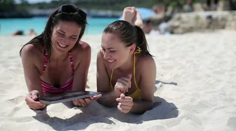 Female friends with tablet computer on the beach, dolly shot HD Stock Footage 11120028