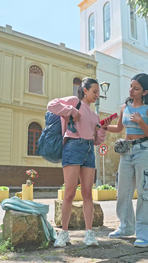 Female friends taking backpack after break while exploring historic city stre 動画素材 333646838