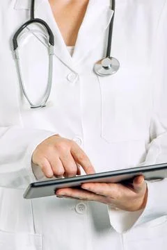 Female general medical practitioner using tablet computer Stock Photos