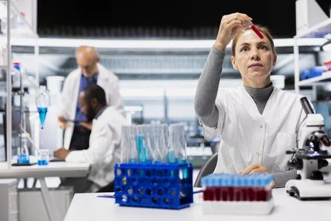 Female geneticist in lab analyzing batch of blood samples for disease markers Stock Photos